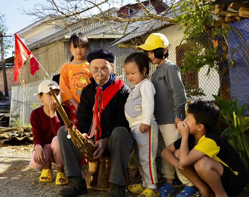 Nghệ nhân ưu tú Mùa A Thào thổi khèn cho các cháu thiếu nhi. Ảnh: Đinh Thùy - TTXVN
