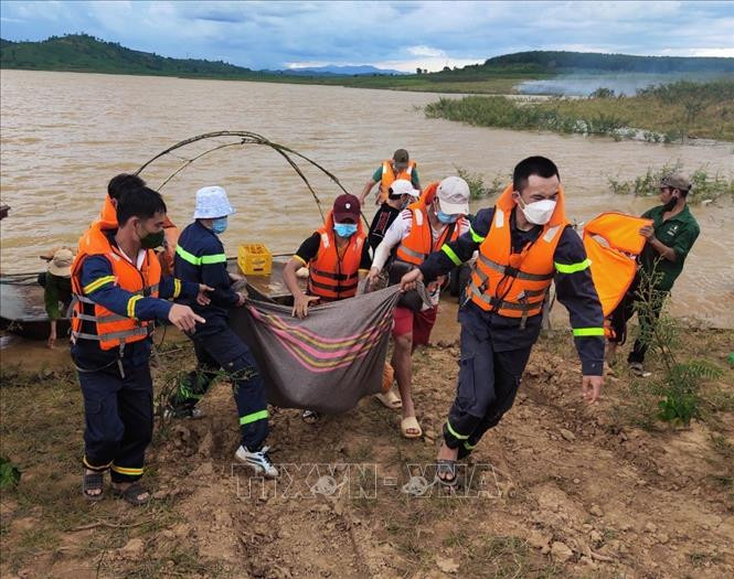 Lực lượng chức năng đưa thi thể nạn nhân lên bờ. Ảnh: Dư Toán – TTXVN
