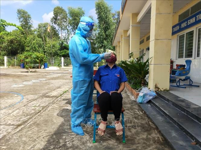 Lấy mẫu xét nghiệm COVID-19 cho học sinh, giáo viên tại Trường Tiểu học Thạnh An. Ảnh: TTXVN phát