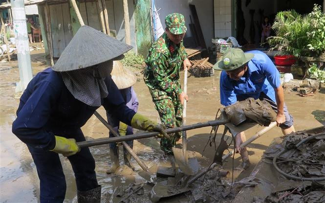 Lực lượng quân đội và đoàn thanh niên dọn dẹp vệ sinh tại thị trấn La Hai, huyện Đồng Xuân. Ảnh: Xuân Triệu - TTXVN