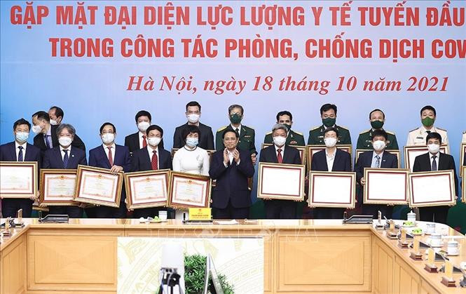 Thủ tướng Phạm Minh Chính trao Bằng khen cho các cá nhân tiêu biểu, xuất sắc trong công tác phòng, chống dịch COVID-19. Ảnh: Dương Giang-TTXVN