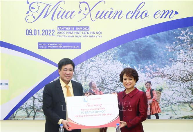 Phó Tổng Giám đốc Công ty Cổ phần Sao Thái Dương Nguyễn Thị Hương Liên trao tặng Fomat chương trình “Tủ sách lớp học” cho Quỹ Bảo trợ trẻ em Việt Nam. Ảnh: TTXVN phát