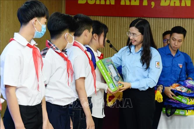 Bí thư Trung ương Đoàn, Chủ tịch Hội đồng Đội Trung ương Nguyễn Phạm Duy Trang trao tặng quà cho các em thiếu nhi có hoàn cảnh khó khăn tại buổi gặp mặt. Ảnh: Minh Đức - TTXVN