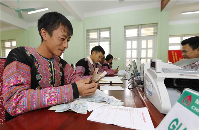 Đồng bào Mông vay vốn tại điểm giao dịch xã Hang Kia, huyện Mai Châu, Hòa Bình. Ảnh: Trần Việt - TTXVN