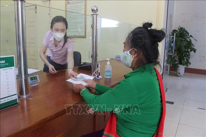 Người dân xã Bồng Khê (Con Cuông, Nghệ An) làm thủ tục tại Ngân hàng Chính sách Xã hội huyện Con Cuông. Ảnh: Bích Huệ - TTXVN