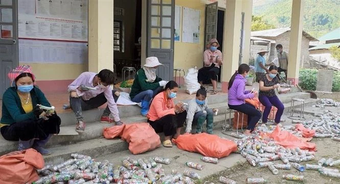 Thành viên Câu lạc bộ “Vệ sinh môi trường” và bà con bản Lun 1, xã Tà Mung, huyện Than Uyên (Lai Châu) làm gạch sinh thái xây dựng tường bao, cổng chào nhà văn hóa của bản. Ảnh: Việt Hoàng-TTXVN 