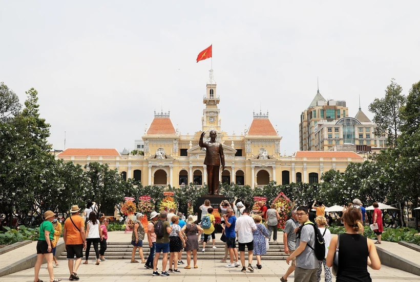 Đoàn khách quốc tế tham quan Tượng đài Chủ tịch Hồ Chí Minh trước Trụ sở HĐND, UBND Thành phố. Ảnh: Hồng Đạt - TTXVN
