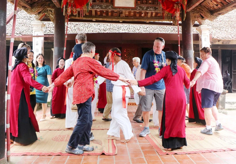 Du khách quốc tế cùng các nghệ nhân và người dân tham gia Hát Xoan tại đình cổ Hùng Lô (xã Hùng Lô, thành phố Việt Trì, tỉnh Phú Thọ). Ảnh: Trung Kiên - TTXVN