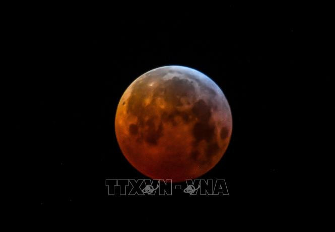 Hiện tượng Siêu Trăng Máu trên bầu trời Godewaersvelde, miền Bắc Pháp. Ảnh: AFP/TTXVN