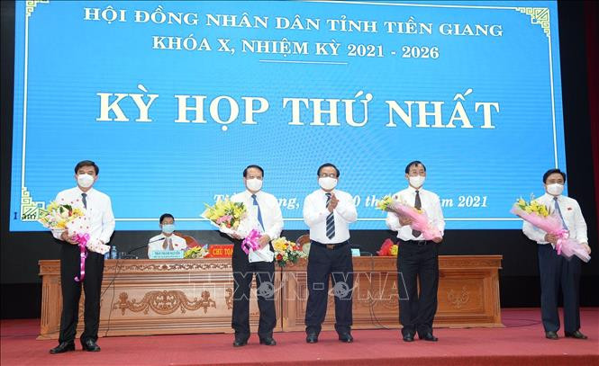 Chủ tịch Hội đồng nhân dân tỉnh Tiền Giang khóa X, nhiệm kỳ 2021 – 2026 Võ Văn Bình tặng hoa chúc mừng lãnh đạo Ủy ban nhân dân tỉnh Tiền Giang tiếp tục trúng cử. Ảnh: Hữu Chí - TTXVN