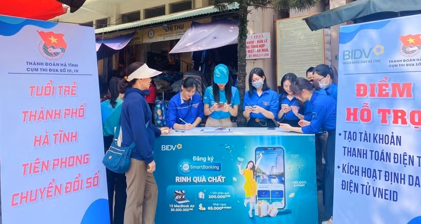 Tuổi trẻ thành phố Hà Tĩnh tổ chức ra mắt mô hình "Chợ thanh toán không dùng tiền mặt" tại chợ Hà Tĩnh, hướng dẫn người dân mở tài khoản thanh toán trực tuyến tại chợ. Ảnh: TTXVN phát