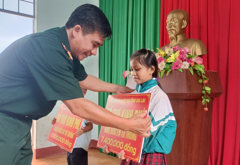 Đại tá Ksơr Lành, Phó Chính ủy Bộ Chỉ huy quân sự tỉnh Gia Lai, tặng quà cho các em học sinh tại xã Ia Chía, huyện Ia Grai, tỉnh Gia Lai. Ảnh: Hồng Điệp - TTXVN