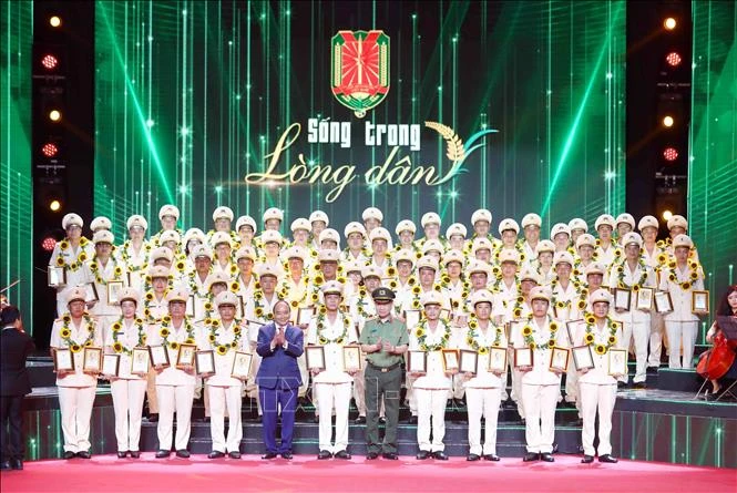 Chủ tịch nước Nguyễn Xuân Phúc và Đại tướng Tô Lâm, Bộ trưởng Bộ Công an tặng hoa và Bằng chứng nhận Trưởng Công an xã tiêu biểu. Ảnh: Phạm Kiên - TTXVN