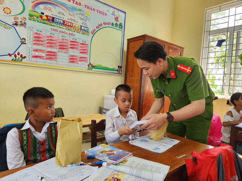 Đối với nhiều em nhỏ xã Quảng Nhâm, Đại uý Tân như một người “anh nuôi” luôn quan tâm, giúp đỡ các em tận tình. Ảnh: Mai Trang-TTXVN