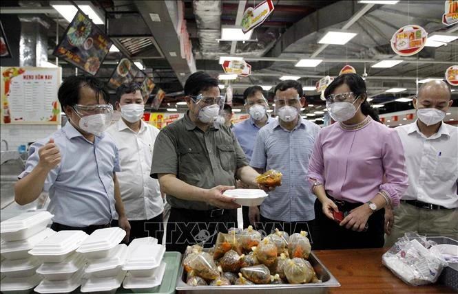Thủ tướng Phạm Minh Chính kiểm tra suất ăn phục vụ người dân trong khu vực phong tỏa, cách ly tại Đại siêu thị Co.op Xtra Phạm Văn Đồng, phường Hiệp Bình Chánh, thành phố Thủ Đức, Thành phố Hồ Chí Minh. Ảnh: Thanh Vũ – TTXVN