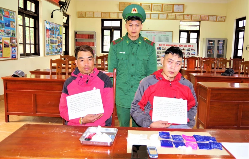 Đối tượng Quàng Văn Thiện (bên trái) và đối tượng Cà Văn Thu cùng tang vật vụ án tại cơ quan chức năng. Ảnh: TTXVN phát