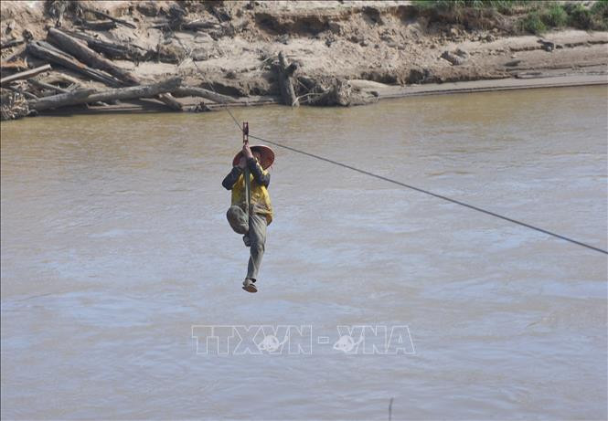 Người dân liều mình đu dây qua sông Pô Kô. Ảnh: Khoa Chương – TTXVN