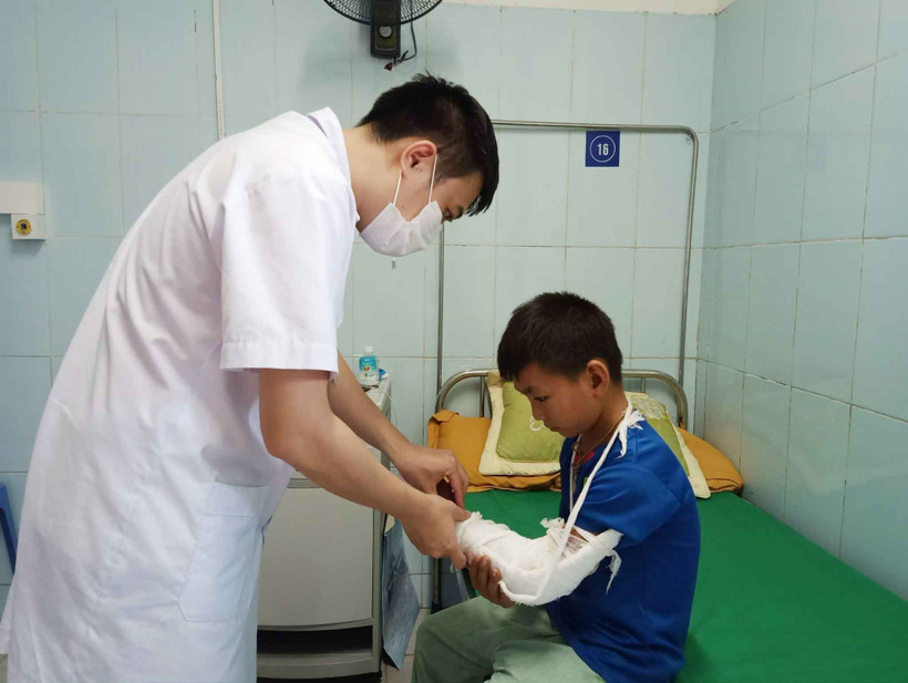 Bác sỹ Bệnh viện Đa khoa tỉnh Lai Châu kiểm tra vết thương cho cháu Hạng A Chù, xã Tả Lèng, huyện Tam Đường do đắp lá cây rừng gây phỏng cánh tay trái. Ảnh: Đinh Thùy-TTXVN