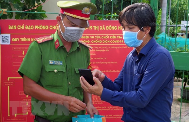 Quét QR để khai báo y tế tại chốt kiểm soát. Ảnh: Xuân Triệu-TTXVN