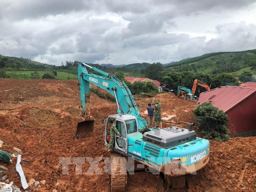 Phương tiện cơ giới đào bới tìm kiếm người bị vùi lấp. Ảnh: TTXVN phát
