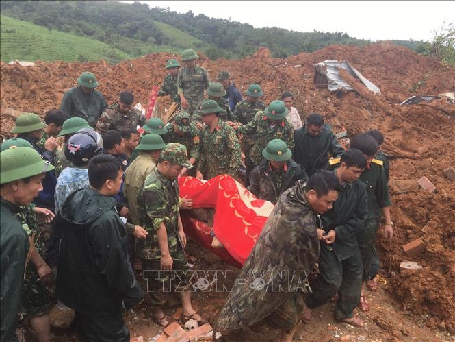 Các lực lượng đưa thi thể người bị nạn ra bên ngoài. Ảnh: TTXVN