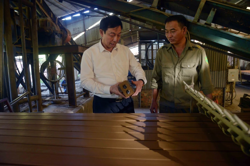 Cựu chiến binh Nguyễn Huy Bẩy (bên trái), Giám đốc Công ty TNHH Sơn Hưng Trung, thành phố Sơn La, kiểm tra sản phẩm. Công ty đã tạo việc làm thường xuyên cho trên 120 cán bộ, công nhân viên, lao động với thu nhập 6 đến 8 triệu đồng/người/tháng. Ảnh: Quang