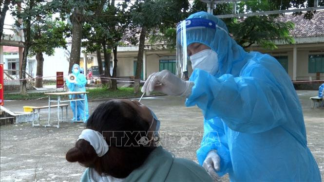 Lấy mẫu xét nghiệp đối với các trường hợp liên quan đến chùm ca bệnh 5 người trong một gia đình. Ảnh: TTXVN phát