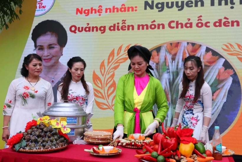 Nghệ nhân Nguyễn Thị Hiền quảng diễn món Chả ốc đèn lồng tiến Vua tại Liên hoan. Ảnh: Trung Kiên - TTXVN