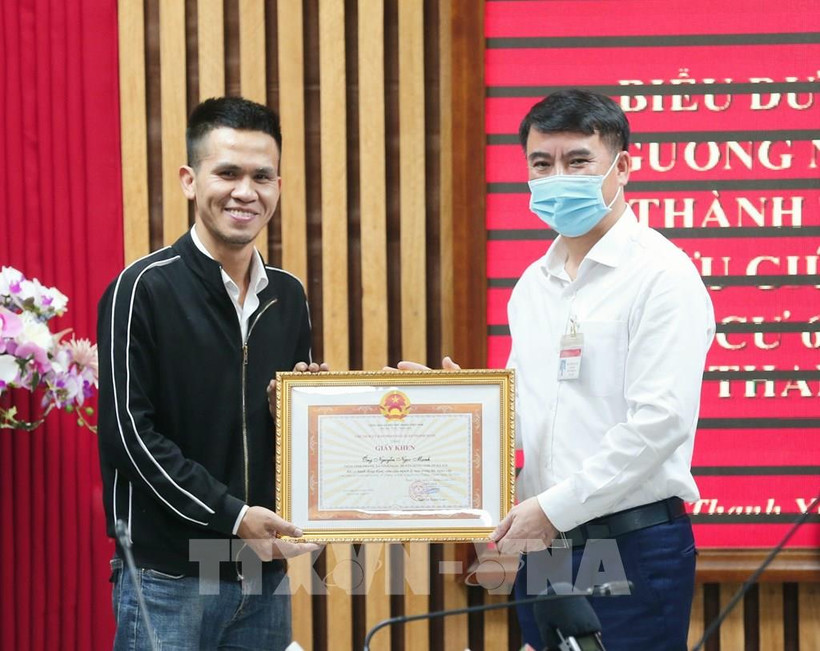 Ông Nguyễn Xuân Lưu, Bí thư Quận uỷ, Chủ tịch UBND quận Thanh Xuân tặng Giấy khen biểu dương tài xế xe tải Nguyễn Ngọc Mạnh (31 tuổi, quê ở huyện Đông Anh) chiều 1/3. Ảnh: Doãn Tấn - TTXVN