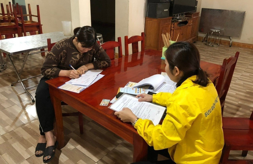Cán bộ bưu điện tỉnh Yên Bái tư vấn cho người dân tham gia bảo hiểm xã hội tự nguyện. Ảnh: TTXVN phát