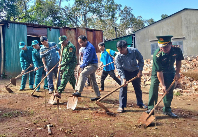 Cán bộ, chiến sĩ Đồn biên phòng Ia Chía và chính quyền địa phương, thôn xóm giúp gia đình chị Rơ Lan H’Líu dựng nhà mới sau khi căn nhà tạm của chị bị hư hại do mưa bão.