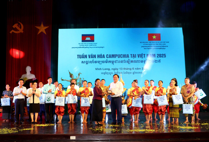 Đại diện đoàn nghệ thuật Vương quốc Campuchia trao quà cho lãnh đạo UBND tỉnh Vĩnh Long . Ảnh: Lê Thúy Hằng/TTXVN cam-1306.jpg