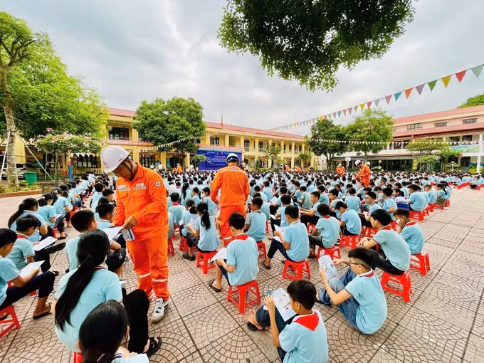 Cán bộ, Công nhân Điện lực Cao Bằng phát tờ rơi, tuyên truyền vận động học sinh thực hiện các biện pháp an toàn điện trong mùa mưa bão. Ảnh: TTXVN phát