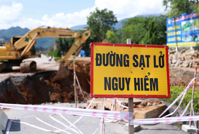 Các đơn vị chức năng cắm cảnh báo nguy hiểm do tình trạng sụt lún tại Km27+120 - Km27+200 trên quốc lộ 4D ở Lai Châu. Ảnh: Quý Trung/TTXVN lai-chau2-2907.jpg