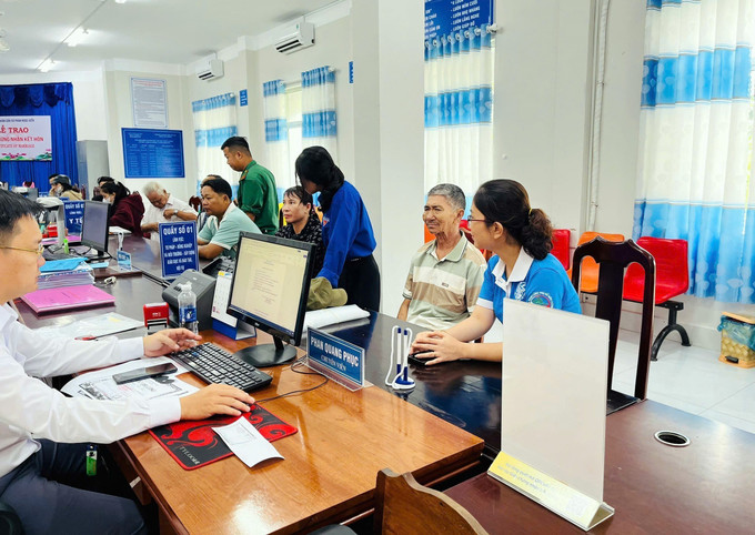 Các hội, đoàn thể chính trị - xã hội giúp người dân làm thủ tục tại trung tâm hành chính xã Phan Ngọc Hiển. Ảnh: TTXVN phát ca-mau1-2809.jpg