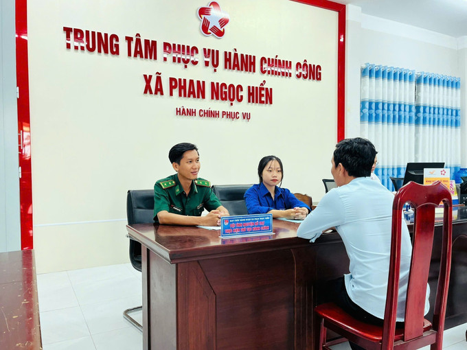 Các tình nguyện viên tư vấn, hỗ trợ người dân đến làm thủ tục hành chính tại xã Phan Ngọc Hiển. Ảnh: TTXVN phát ca-mau3-2809.jpg