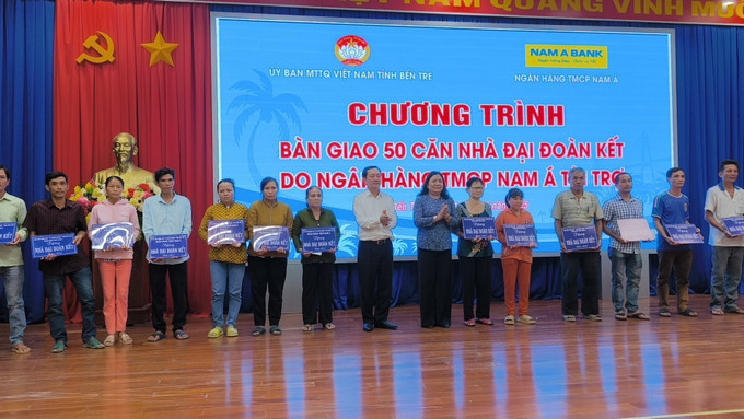 Trao bảng tượng trưng và quà cho người dân được nhận nhà mới. Ảnh: Huỳnh Phúc Hậu/TTXVN ben-tre1-3105.jpg