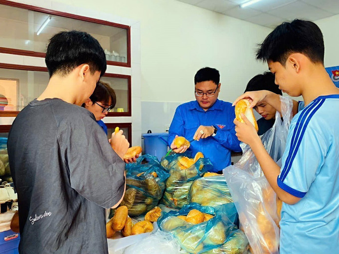 Anh Lại Phước Trường Thành (giữa), Bí thư Đoàn phường Cái Khế, quận Ninh Kiều cùng các tình nguyện viên nấu cơm miễn phí cho bệnh nhân có hoàn cảnh khó khăn tại mô hình "Bếp ấm". Ảnh: TTXVN phát can-tho2-230625.jpg