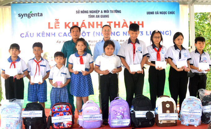 Ban tổ chức trao quà cho học sinh vượt khó học tốt.