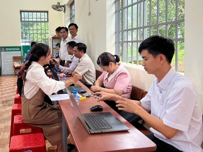 Cán bộ xã Phước Sơn (Đồng Nai) giải quyết thủ tục hành chính cho người dân. Ảnh: K GỬIH/TTXVN dong-bao2-1707.jpg