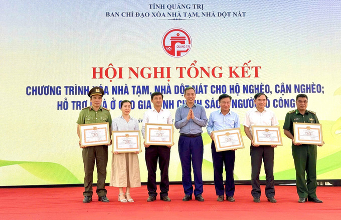 Trao Bằng khen của UBND tỉnh Quảng Trị cho các cá nhân có thành tích xuất sắc trong Chương trình xóa nhà tạm của tỉnh Quảng Trị. Ảnh: Nguyên Linh/TTXVN quang-tri1-2306.jpg