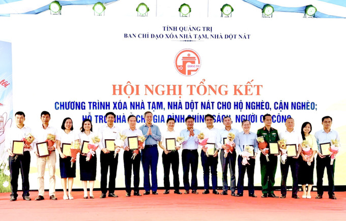 Trao Bằng khen của UBND tỉnh Quảng Trị cho các tập thể có thành tích xuất sắc trong Chương trình xóa nhà tạm của tỉnh Quảng Trị. Ảnh: Nguyên Linh/TTXVN quang-tri2-2306.jpg