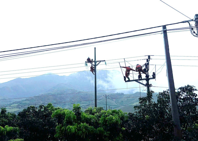 Công nhân Công ty Điện lực Sơn La nỗ lực thi công, sửa chữa hệ thống lưới điện tại xã Mường Lầm. Ảnh: TTXVN phát son-la2-0708.jpg