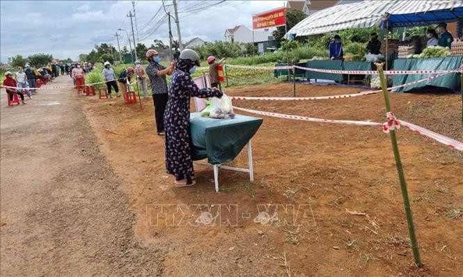 Người dân có hoàn cảnh khó khăn nhận nhu yếu phẩm từ “Gian hàng 0 đồng”. Ảnh: Ngọc Minh - TTXVN