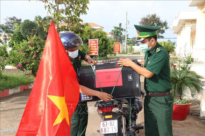 Cán bộ Đồn Biên phòng Kiểng Phước chuẩn bị loa di động để đi tuyên truyền về bầu cử. Ảnh: Hữu Chí – TTXVN