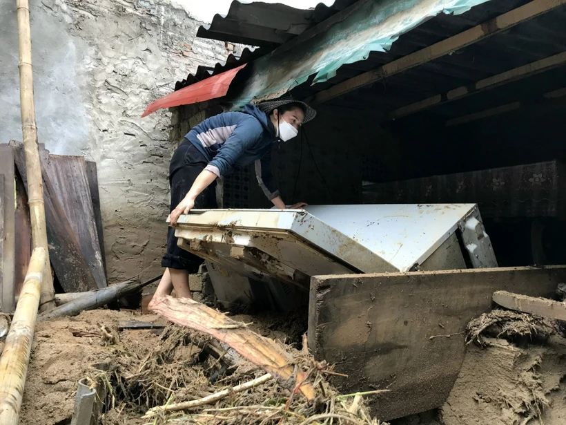 Người dân khối 1, thị trấn Mường Xén, Kỳ Sơn (Nghệ An), cố gắng tìm kiếm những tài sản còn sót lại sau trận lũ quét. Ảnh: Văn Tý-TTXVN