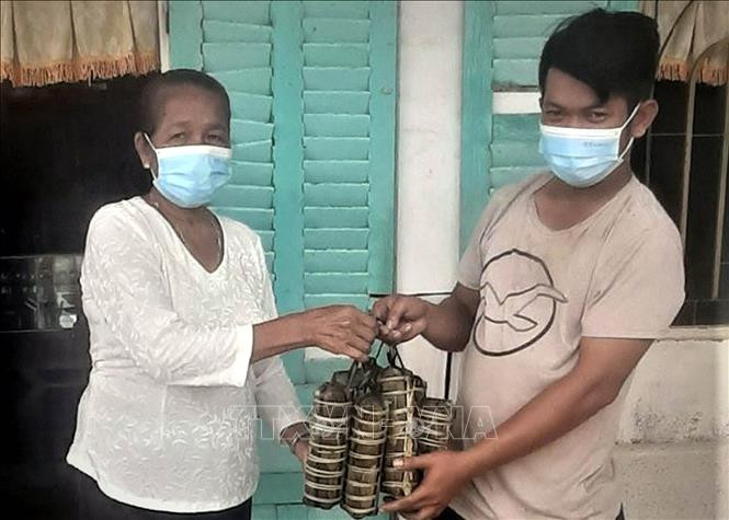 Bà Lý thị Phel (71 tuổi) ở Ấp Phônô Cam Both, xã Tham Đôn, huyện Mỹ Xuyên (Sóc Trăng) gói 50 đòn bánh tét tặng các điểm chốt phòng dịch. Ảnh TTXVN phát