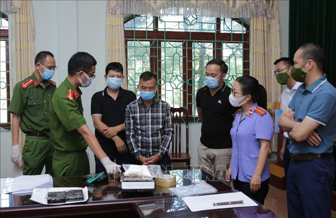 Đối tượng Sùng A Cừ, sinh năm 1999 ở bản Si Ma 2, xã Chung Chải, huyện Mường Nhé, tỉnh Điện Biên chứng kiến ban chuyên án cân heroin tang vật của vụ án. Ảnh: Quý Trung – TTXVN