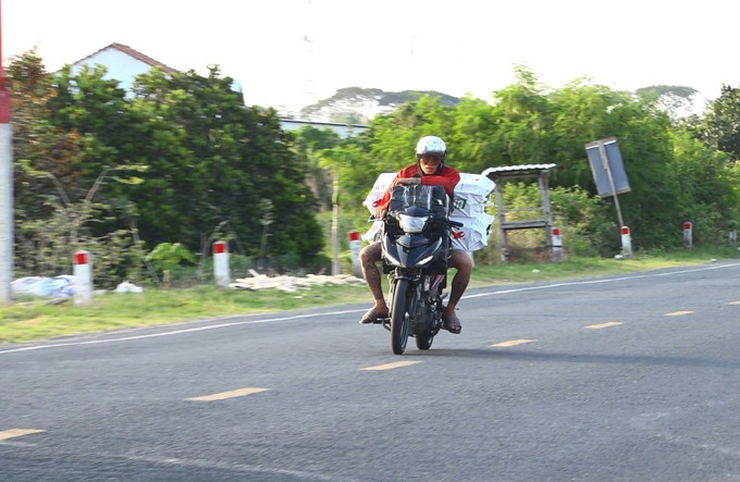 Đối tượng điều khiển xe mô tô với tốc độ cao để vận chuyển thuốc lá lậu trên Quốc lộ 30, đoạn qua xã An Long, tỉnh Đồng Tháp. Ảnh: Nhựt An/TTXVN