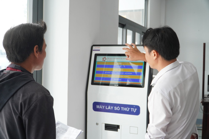 Hướng dẫn người dân lấy số thứ tự khi thực hiện thủ tục hành chính tại Trung tâm Phục vụ hành chính công xã Hỏa Lựu (Cần Thơ). Ảnh: Hồng Thái/TTXVN can-tho-1.jpg